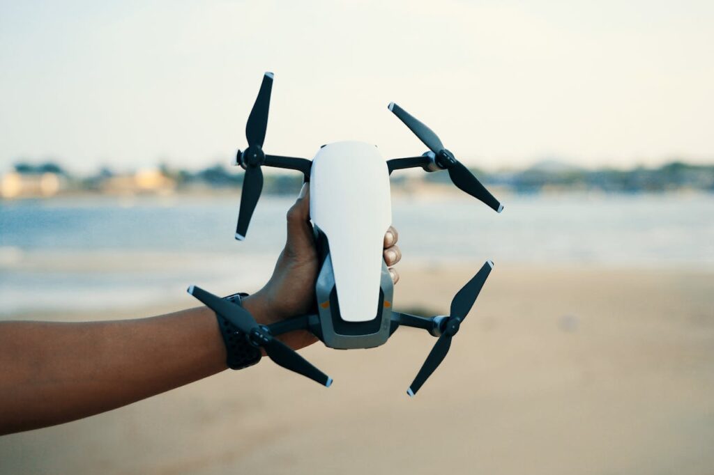 Person Holding White And Black Quadcopter Drone